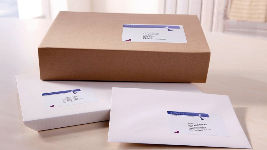Caja de cartón y sobres blancos con etiquetas de envío impresas
