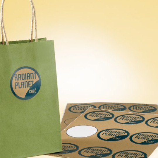 Bolsa de papel verde con etiquetas redondas personalizadas en papel kraft sobre fondo amarillo