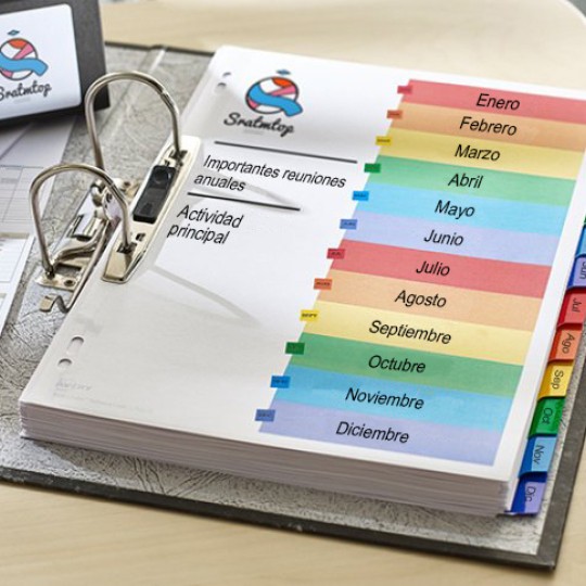 Archivador abierto con separadores de meses de colores en un escritorio