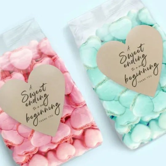 Bolsas de plástico con objetos de color rosa y azul claro y 2 etiquetas adhesivas en forma de corazón