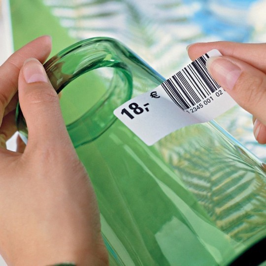 Colocar a mano una etiqueta adhesiva removible con el precio en un recipiente de vidrio