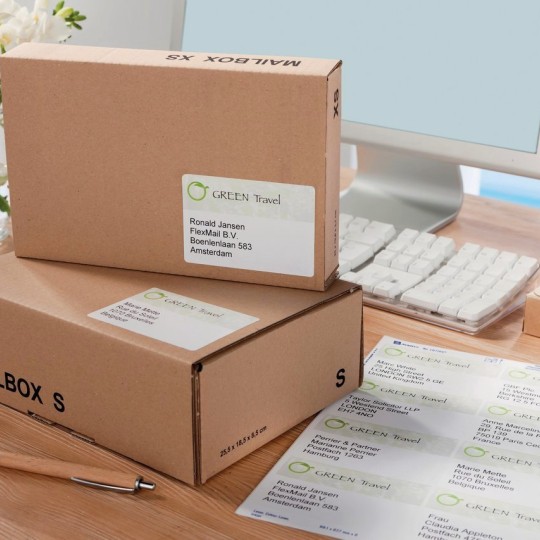 Dos cajas de cartón con etiquetas de envío y una hoja de etiquetas en un escritorio