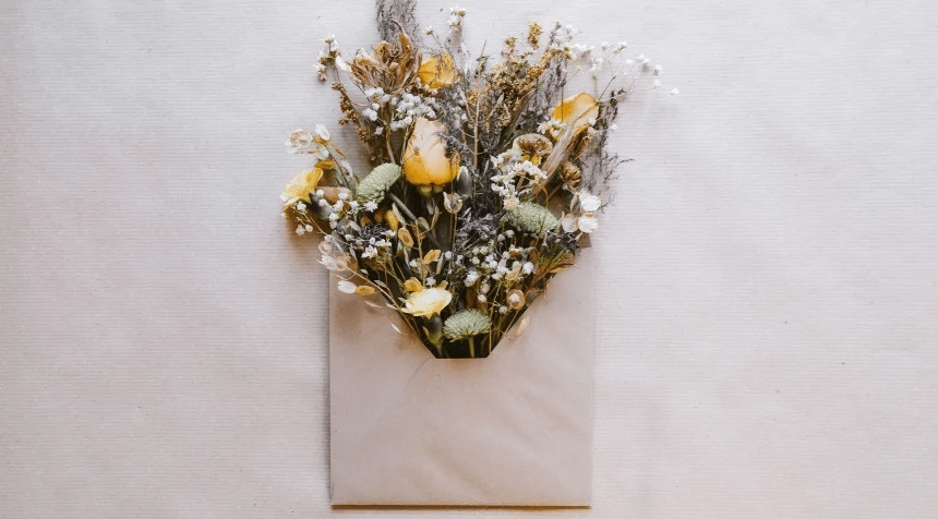 Tarjeta de invitación de boda con flores saliendo como decoración