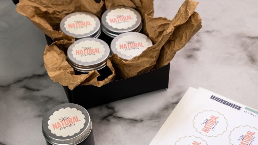 Envases de crema dispuestos sobre una mesa, decorados con etiquetas de acabado perlado