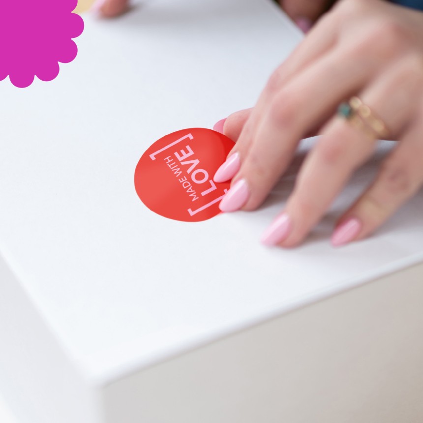 Mano aplicando una etiqueta en una caja de regalo