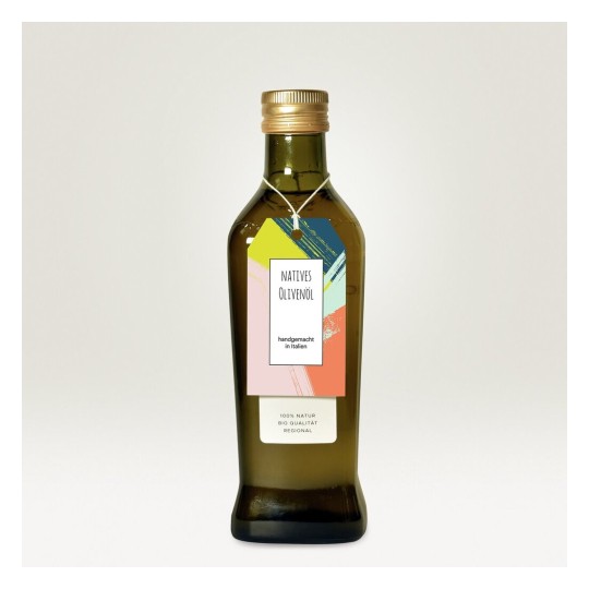 La imagen muestra una botella de aceite de oliva virgen extra, con una etiqueta colorida que indica que es artesanal y hecho en Italia. La botella es de vidrio oscuro y tiene una tapa de plástico dorado.