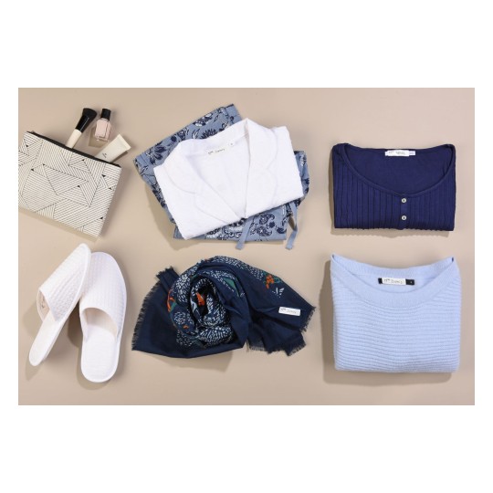 La imagen muestra varias prendas de ropa y accesorios, incluyendo blusas, un bolso con patrón geométrico, una bufanda y unas pantuflas blancas.