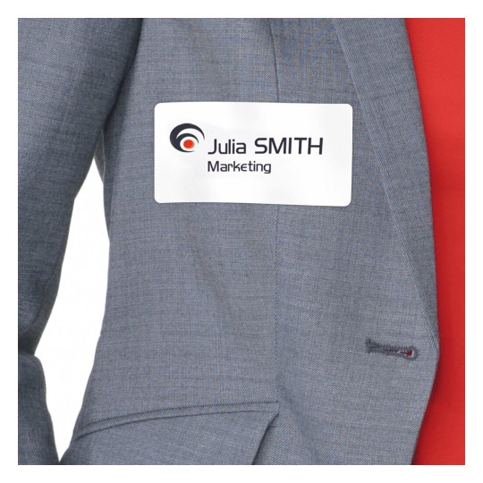 La imagen muestra una etiqueta de identificación con el nombre 'Julia SMITH' y el texto 'Marketing', colocada sobre una chaqueta gris con una parte roja visible detrás.