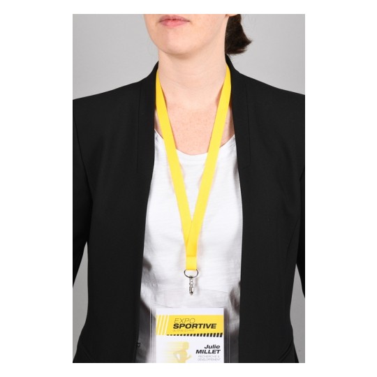 La imagen muestra a una persona con un blazer negro y una camiseta blanca, usando un distintivo de identificación con un cordón amarillo que dice 'EXPO SPORTIVE' y un nombre asociado.