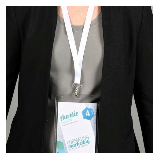 En la imagen se puede ver a una persona que lleva puesta una chaqueta negra y una camiseta gris. Tiene un distintivo colgado que muestra su nombre y otros detalles relacionados con un evento de formación en marketing.