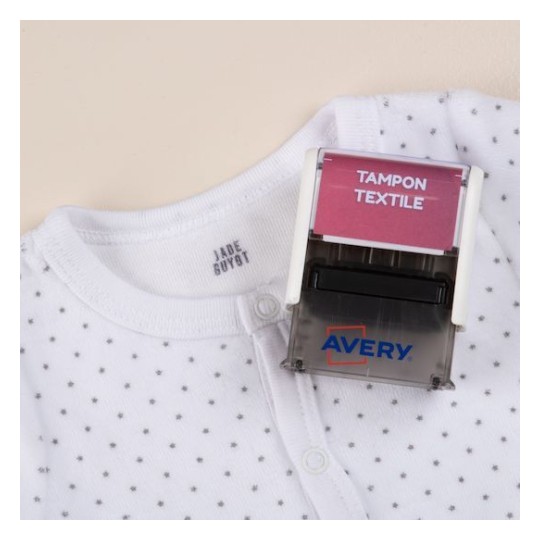 En la imagen hay una camiseta blanca con un estampado de puntos pequeños y un marcador de tela que dice 'TAMPON TEXTILE' de la marca Avery.