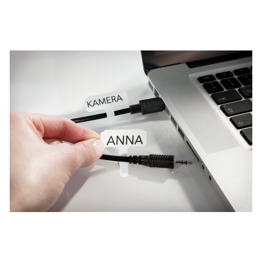 La imagen muestra una mano que sostiene una etiqueta con el nombre 'ANNA' juntando cables que están conectados a una computadora portátil con una etiqueta 'KAMERA'.