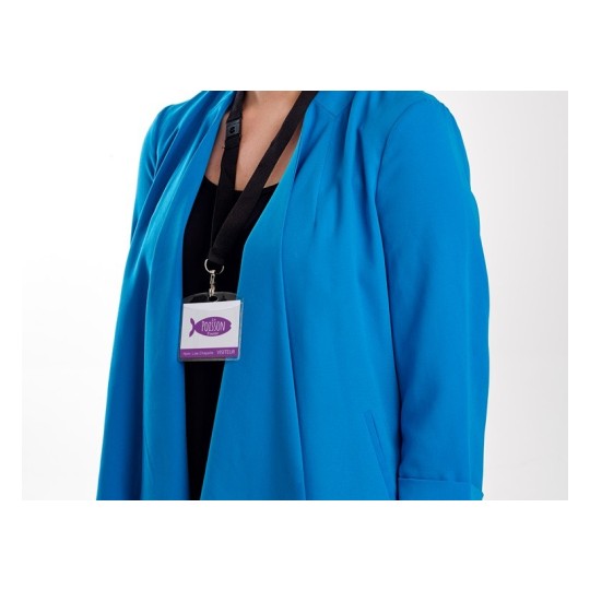 La imagen muestra una persona vestida con una chaqueta azul y un collar con una placa que parece indicar que es un visitante, posiblemente en un evento o lugar de trabajo.