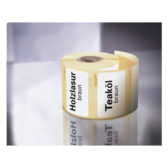 La imagen muestra un rollo de etiquetas con las palabras 'Holzlasur' y 'Teaköl' en letras negras sobre un fondo claro, indicando productos para tratar madera en color marrón.