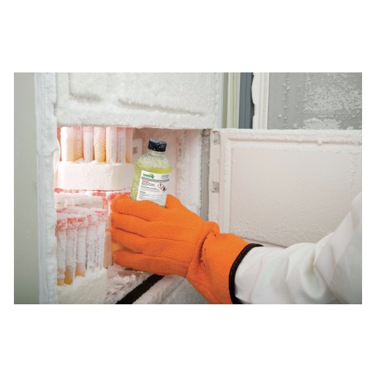 En la imagen se observa un congelador con hielo acumulado. Una mano con un guante naranja sostiene una botella mientras se retira del congelador.