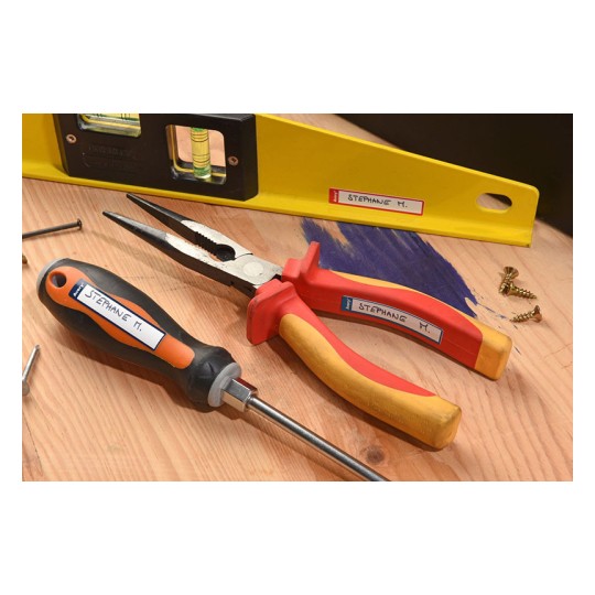 La imagen muestra herramientas de trabajo sobre una superficie de madera. Hay una niveladora amarilla, un par de alicates rojos y amarillos, y un destornillador negro y naranja. También se ven algunos tornillos y un poco de pintura azul.