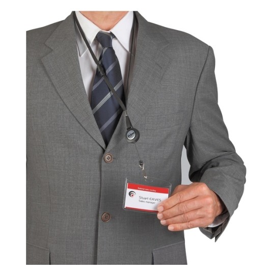 Una persona con un traje gris y corbata, sosteniendo un identificador de nombre que dice 'Stuart Eaves'.