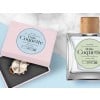 Un perfume y una caja con un reloj con etiquetas adhesivas redondas personalizadas