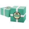 Dos cajas de color verde azulado con cinta blanca y etiqueta redonda personalizada