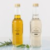 Dos botellas de cristal con aceite y vinagre con etiquetas redondas transparentes que indican el producto