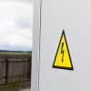 Etiqueta adhesiva triangular amarilla con un rayo que indica peligro de descarga eléctrica