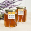 Dos frascos de miel con etiquetas colgantes personalizadas con abeja y texto