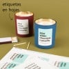 Dos velas con etiquetas rectangulares personalizadas. Al lado, hojas de etiquetas ya preparadas