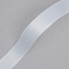 La imagen muestra una cinta adhesiva de color blanco sobre un fondo gris. La cinta tiene una textura lisa y brillante.