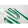 La imagen muestra varios lanyards verdes con patrones oscuros y clips metálicos. También hay un portatarjetas transparente en la parte inferior con un diseño floral.