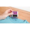 Una persona está utilizando un sello de ropa sobre una camiseta azul, que está sobre una superficie de madera clara. El sello dice 'Clothing Stamp' y es de la marca Avery.